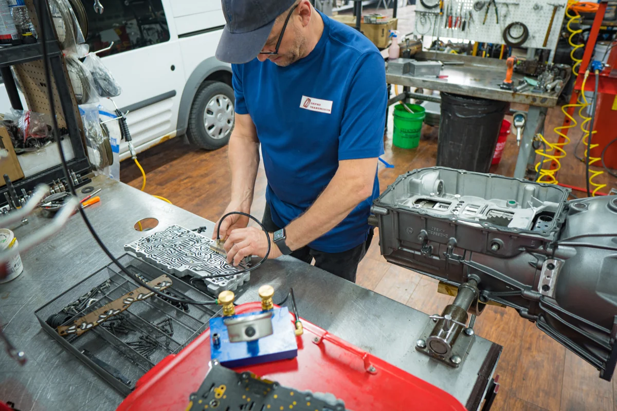 AMPro technician assembling transmission components at a workbench